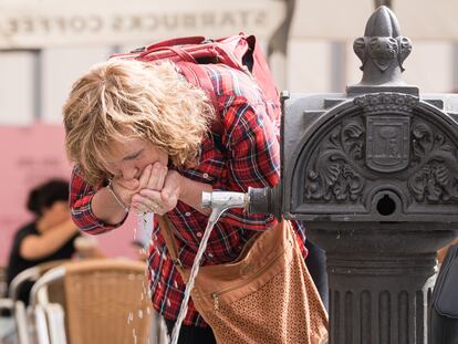 Una mujer bebe agua de una fuente pública, este 24 de abril en Madrid.