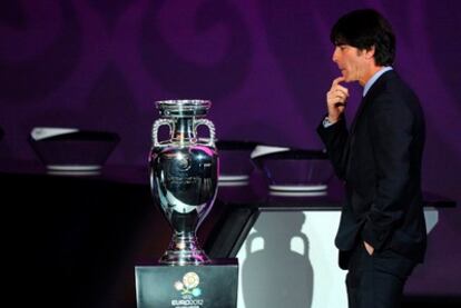 El seleccionador alemán, Löw, observa la Copa durante el sorteo.