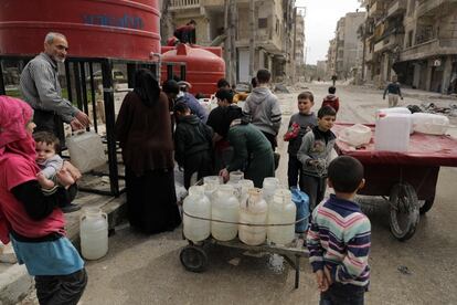 Un grupo de ciudadanos sirios hace cola en un depósito de agua en el barrio de al- Shaar, en el norte de Alepo (Siria). Este barrio, antes de ser reconquistado por las fuerzas del gobierno, era controlado por los rebeldes.