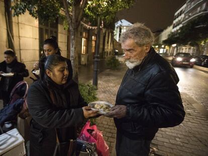 Gabriela García ofreciendo platos de arroz a las puertas del Samur Social.