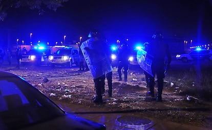 Agentes de la Policía Antidisturbios vigilan a los jóvenes congregados en Torre Pacheco, esta madrugada.