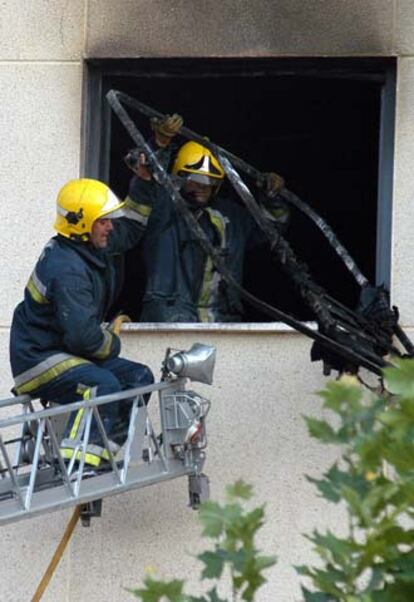 Dos bomberos, en una ventana del piso siniestrado en Ciudad Real.