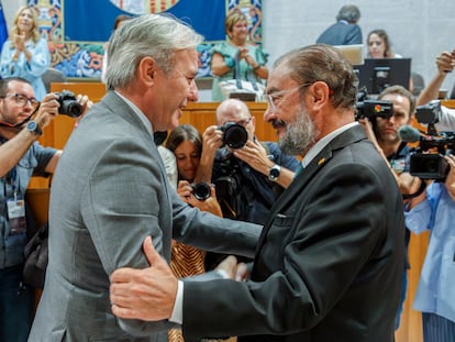 El popular Jorge Azcón (a la izquierda) saluda a su antecesor en el cargo, el socialista Javier Lambán, tras ser investido como presidente de Aragón este jueves, en Zaragoza.