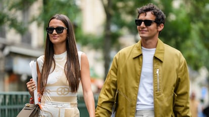 Una pareja de la mano paseando por la calle.