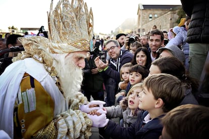 El Rey Melchor saluda a los niños que han acudido a recibirle en el puerto de Barcelona antes de la cabalgata.