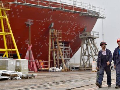 Dois trabalhadores passam ao lado de uma embarcação que está sendo consertada, em Saint-Nazaire, em setembro de 2017.