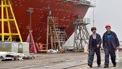 Dois trabalhadores passam ao lado de uma embarcação que está sendo consertada, em Saint-Nazaire, em setembro de 2017.