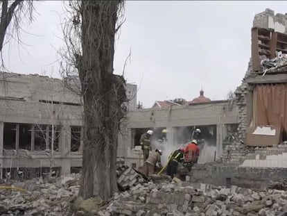 Trabajadores retiran los escombros de un colegio destruido por los bombardeos en Ucrania.