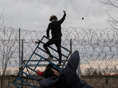 Un migrante tiraba una piedra a la policía griega, que le impedía entrar en el país, en el paso de Pazarkule, Turquía, en marzo de 2020.