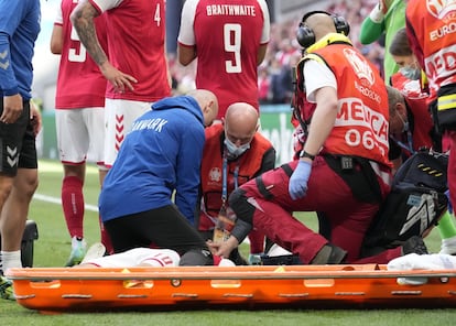 Personal sanitario atiende al futbolista en el terreno de juego. La UEFA ha comunicado que el partido ha sido suspendido.