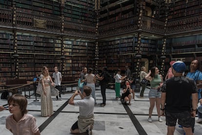 Visitors and tourists photograph the main hall of the Real Gabinete Português de Leitura. 