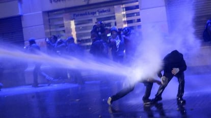 A polícia lança jatos de água contra manifestantes.