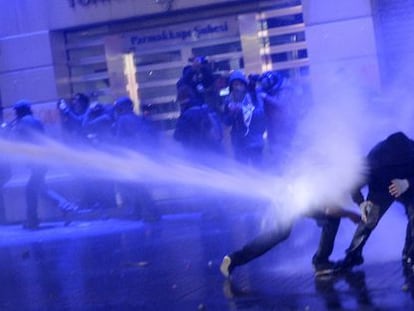 Los antidisturbios lanzan un ca&ntilde;&oacute;n de agua contra dos manifestantes esta noche en Estambul. 