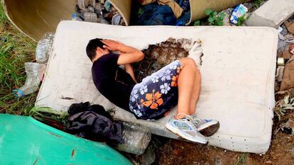 Un menor descansa en un colchón roto en un descampado en Melilla.