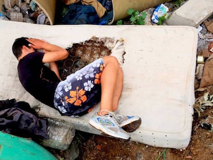 Un menor descansa en un colchón roto en un descampado en Melilla.