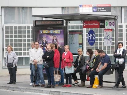 Persones esperant en una parada d'autobús.