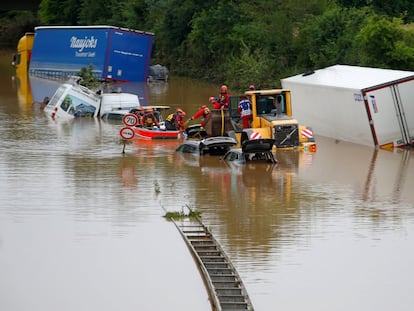 Miembros de un equipo de rescate trabajan junto a coches atascados en la carretera tras las fuertes lluvias en Erftstadt, Alemania.