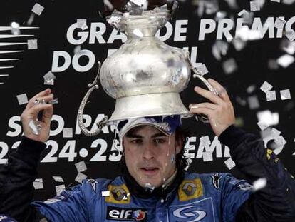 Fernando Alonso se riega de cava con la copa de campeón.