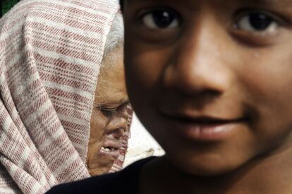 Un niño posa frente a una mujer enferma de lepra en uno de los suburbios de Calcuta