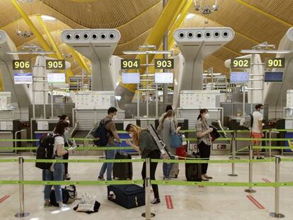 Pasajeros con sus maletas en las instalaciones de la Terminal T4 del aeropuerto de Madrid-Barajas.