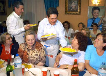 El ministro de Defensa, Federico Trillo, junto al candidato del PP a la alcaldía de Gandía, Fernando Mut, sirve platos de paella en una comida con mujeres organizada por su partido.