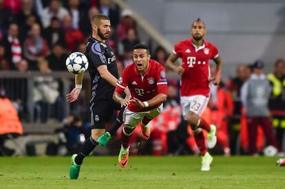 El delantero del Madrid Karim Benzema y el centrocampista del Bayern Thiago Alcantara (c) compiten por el balón en un momento del partido.