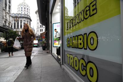 Una mujer camina junto a una casa de intercambio de divisas, en el centro de Buenos Aires.