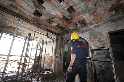 Un bombero comprueba el estado de uno de los apartamentos afectados por el fuego.