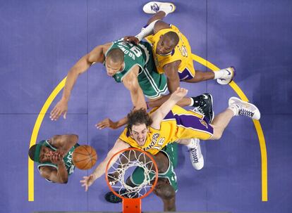 Pau Gasol de los Lakers, trata de encestar ante James Posey (izquierda) y P. J. Brown (detrás) en presencia de su compañero Kobe Bryant, durante un partido en 2008.