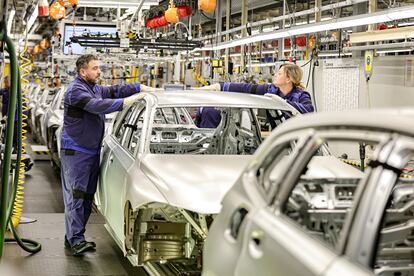 Dos trabajadores en una cadena de montaje de BMW en Baviera, Alemania.