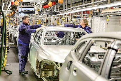 Dos trabajadores en una cadena de montaje de BMW en Baviera, Alemania.