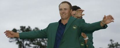 Bubba Watson, el campeón saliente, ayuda a Jordan Spieth a vestir la chaqueta verde.