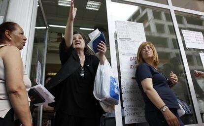 Unas mujeres aguardan en la entrada del Fondo de Salud Estatal para recibir medicamentos en Atenas.