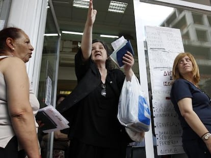 Unas mujeres aguardan en la entrada del Fondo de Salud Estatal para recibir medicamentos en Atenas.