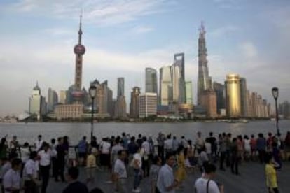 Un grupo de turistas observa una vista panormica del distrito financiero del Pudong, en Shaghi (China).