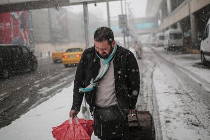 El aeropuerto Atatürk de Estambul, el principal de Turquía y uno de los cinco mayores de Europa, ha quedado prácticamente paralizado por las densas nevadas que comenzaron el martes, con casi todos los vuelos cancelados o retrasados. En la imagen, un pasajero en el exterior del Aeropuerto de Estambul (Turquía).