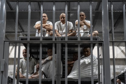 A closed circuit watches the prisoners like a silent god. They eat beans and rice with their hands because forks and knives could become deadly weapons. In the photo, six inmates are pictured inside their cell at the Cecot. 