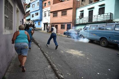 Vecinos y manifestantes corren en pleno altercado con la policía tras las protestas en apoyo a los militares sublevados.