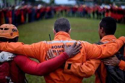 Cerca de 376 membros das forças de segurança, incluindo bombeiros e policiais, de Minas Gerais e de outras regiões do país participam do trabalho com a ajuda de escavadeiras. Na foto, os bombeiros rezam antes de retomar a busca por vítimas.