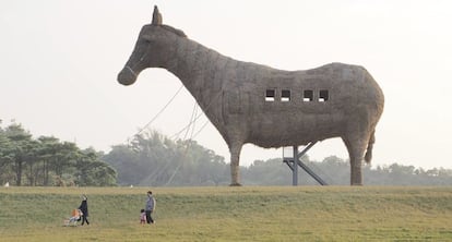 Una familia pasa en el sur de Taiwán junto a un caballo de Troya de 20 metros de alto, 20 de largo y 8 de ancho, esculpido con heno, bambú y acero.