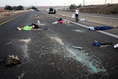 A man photographs bodies of several people after the Hamas attack in the Sderot area of southern Israel on October 7.