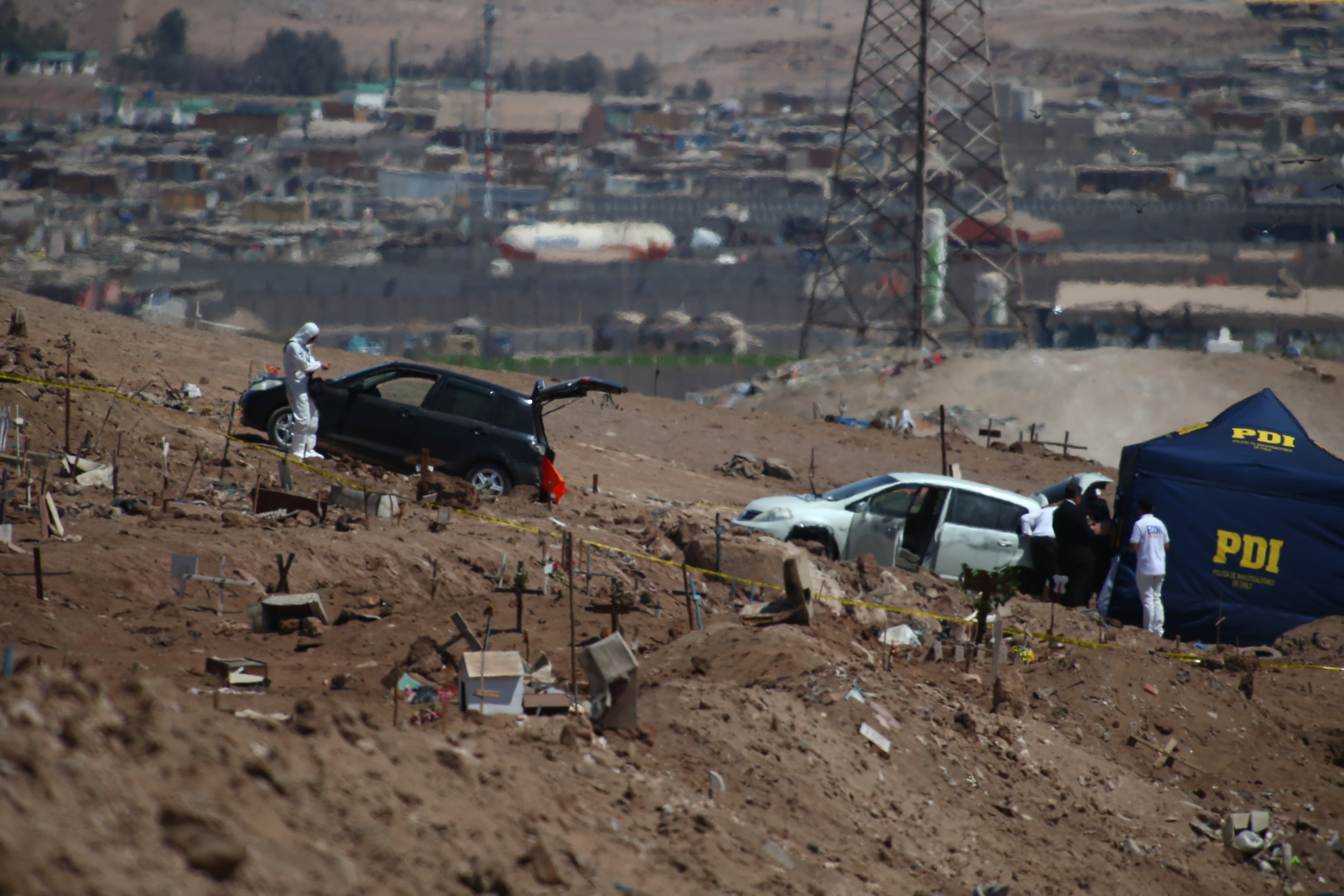 Agentes de la PDI examinan un vehículo donde se encontraron tres personas muertas, crimen con posible relación con el Tren de Aragua, en Altro Hospicio (Chile),el 3 de abril. 