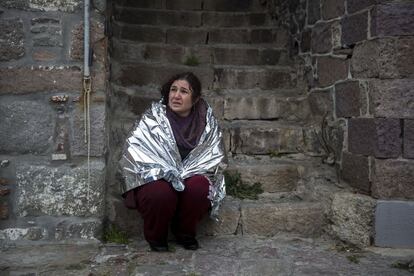 Una mujer espera, envuelta en una s&aacute;bana t&eacute;rmica, tras haber sido rescatada despu&eacute;s de que se hundiera el barco en el que viajaba junto a decenas de refugiados en el trayecto de Turqu&iacute;a a la isla griega de Lesbos.