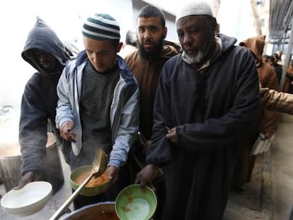 Presos de un centro de detenci&oacute;n de Misrata hacen cola para recibir su raci&oacute;n de comida. 