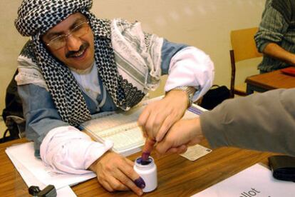 El presidente de una mesa electoral de Berlín moja en tinta el dedo de un elector para evitar que vote dos veces.