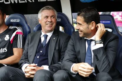 El entremador del Real Madrid. el italiano Carlo Ancelotti (i) y su ayudante, Fernando Hierro sonr&iacute;en en el banquillo durante el partido ante el Deportivo.