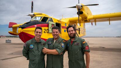 Los pilotos David Juan Conde, izquierda, y Aitor Bellido, derecha, posan junto al mecánico Juan Sánchez frente al hidroavión que tripulan en la base militar de Torrejón de Ardoz en Madrid.