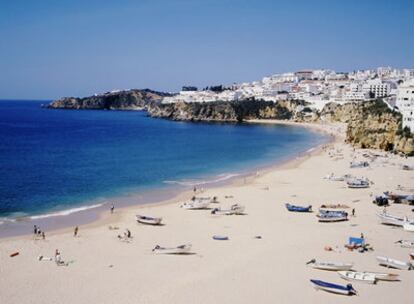 El gran arenal de aguas cristalinas en el Algarve da la bienvenida a los visitantes con su bonita estampa de barcos pesqueros de colores