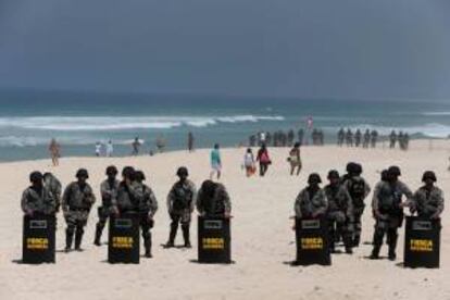 Integrantes de la Fuerza Nacional de Seguridad forman fueron registrados este lunes la formar una barrera cerca del hotel donde se realizará la subasta por una participación mayoritaria en el yacimiento petrolero Libra, en la playa de la Barra da Tijuca, en Río de Janeiro (Brasil).