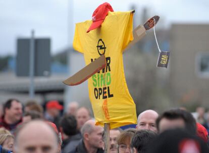 Los trabajadores de la planta de Kaiserlautern muestran una camiseta con el eslogan <i>Somos Opel</i>, acuchillada simbólicamente por una espada GM.